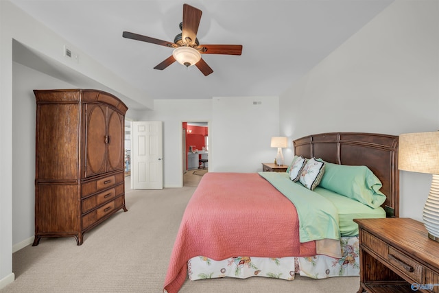 bedroom with a ceiling fan, light carpet, connected bathroom, and baseboards