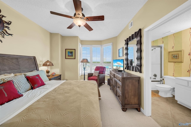 bedroom with light tile patterned floors, connected bathroom, visible vents, and a textured ceiling