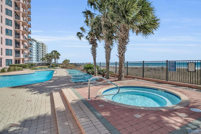 view of pool with fence and a community hot tub