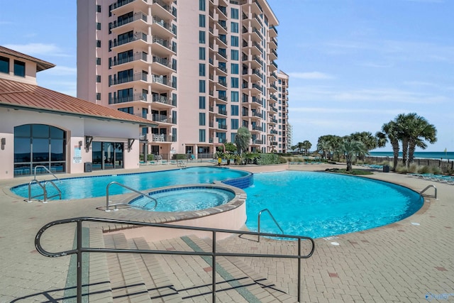 community pool with a community hot tub and a patio area