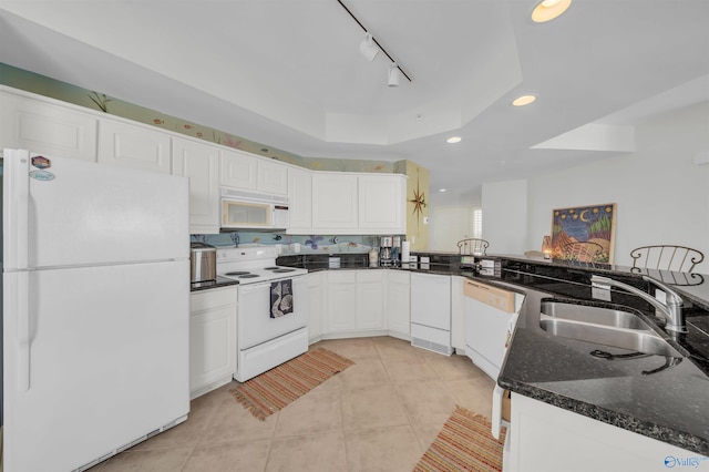 kitchen featuring white appliances, light tile patterned floors, a tray ceiling, white cabinetry, and a sink