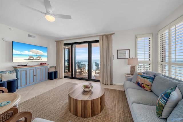 living room featuring a healthy amount of sunlight, visible vents, ceiling fan, and light tile patterned flooring