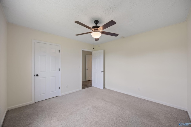 unfurnished bedroom featuring baseboards, a ceiling fan, a textured ceiling, and carpet
