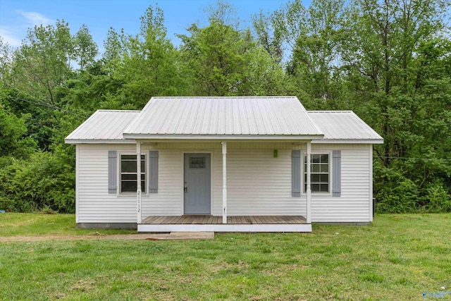 view of front of property with metal roof, a porch, and a front lawn