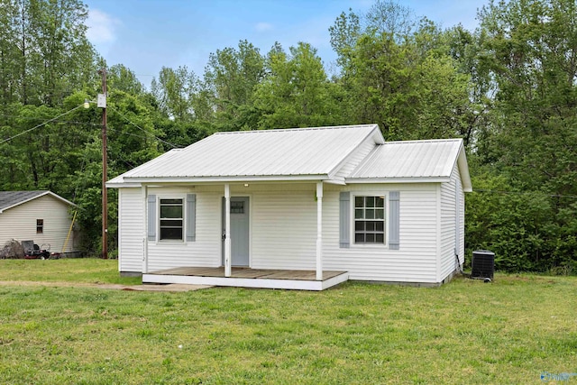 view of front of property with a porch, a front lawn, metal roof, and central air condition unit