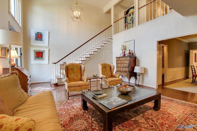 1625 River Bend Pl SE, Decatur, AL 35601 - living area featuring a high ceiling, wood finished floors, stairs, a chandelier, and a wainscoted wall
