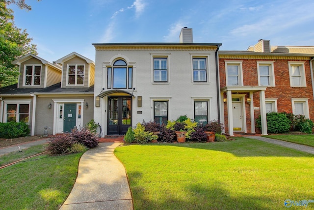1625 River Bend Pl SE, Decatur, AL 35601 - view of front facade featuring a chimney, brick siding, a front lawn, and french doors