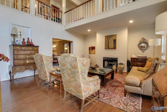 1625 River Bend Pl SE, Decatur, AL 35601 - living area with wood finished floors, a fireplace, a high ceiling, crown molding, and a chandelier