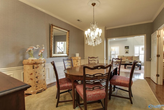 1625 River Bend Pl SE, Decatur, AL 35601 - dining area with a chandelier, crown molding, wainscoting, and a decorative wall