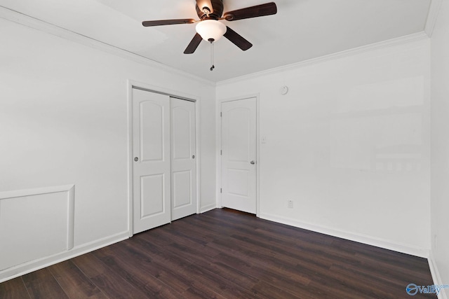 unfurnished bedroom featuring a closet, ceiling fan, crown molding, and dark hardwood / wood-style floors