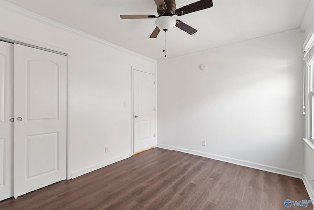 unfurnished bedroom featuring ceiling fan, crown molding, dark wood-type flooring, and a closet