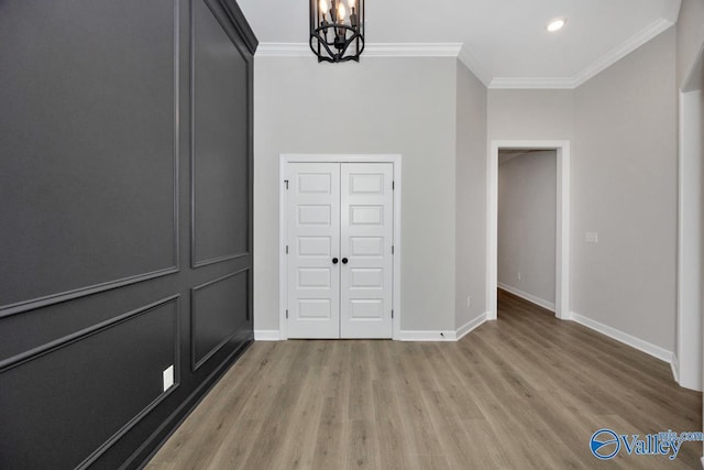 interior space with crown molding, light hardwood / wood-style flooring, a closet, and a chandelier