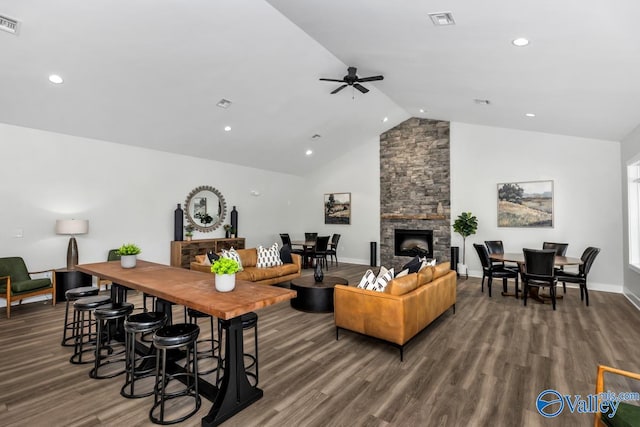 living room with dark wood-type flooring, a fireplace, and high vaulted ceiling