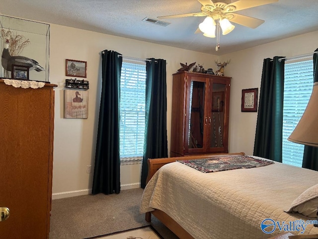 bedroom featuring light carpet, ceiling fan, and a textured ceiling