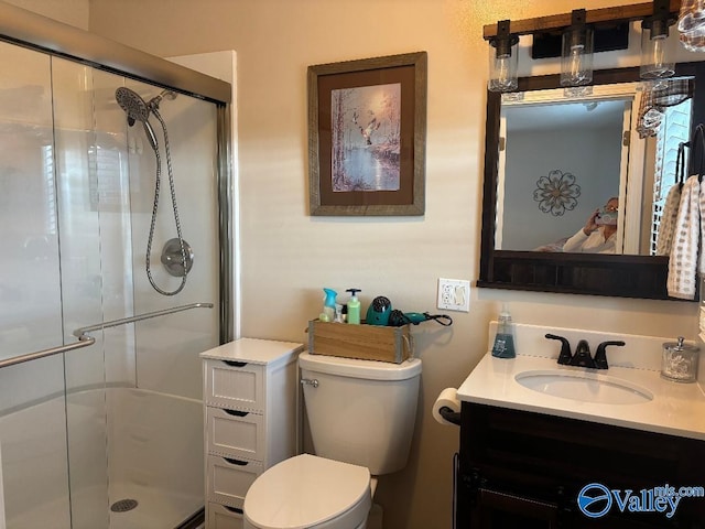 bathroom featuring vanity, an enclosed shower, and toilet