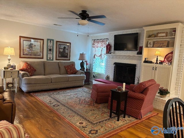 living room featuring a fireplace, crown molding, and dark wood-type flooring