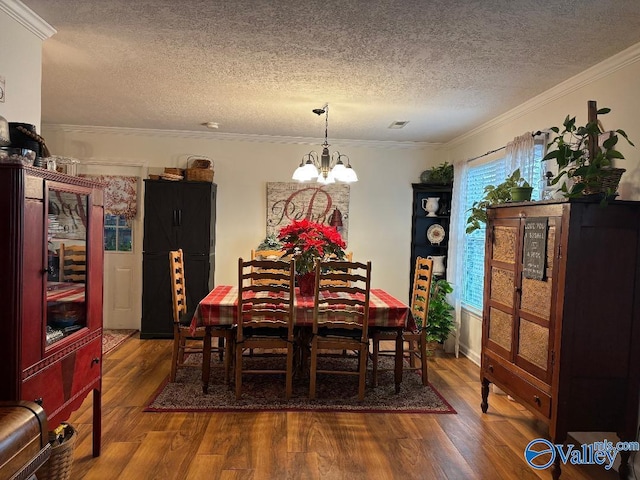 dining room with a notable chandelier, hardwood / wood-style flooring, ornamental molding, and a textured ceiling