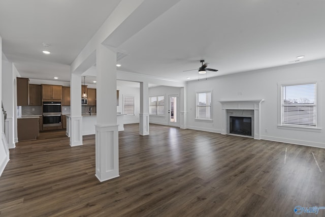 193 Chesire Cove Ln, New Market, AL 35761 - unfurnished living room with dark wood-type flooring, baseboards, recessed lighting, a glass covered fireplace, and a ceiling fan