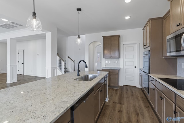 193 Chesire Cove Ln, New Market, AL 35761 - kitchen with a sink, dark wood-style floors, arched walkways, appliances with stainless steel finishes, and light stone countertops