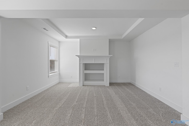 193 Chesire Cove Ln, New Market, AL 35761 - unfurnished living room with visible vents, baseboards, a tray ceiling, light carpet, and a fireplace