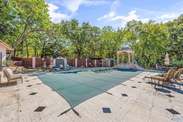 view of pool with a patio area and a shed