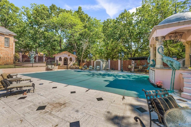 view of swimming pool with a patio and a shed