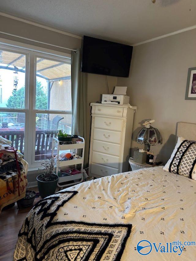 bedroom featuring wood finished floors and crown molding