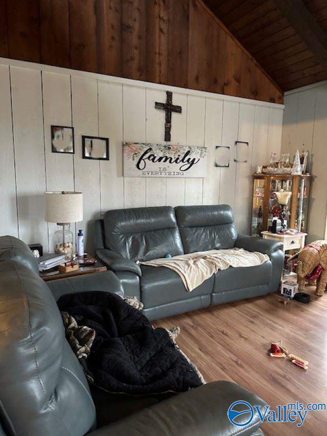 living area with wooden ceiling, vaulted ceiling with beams, and wood finished floors