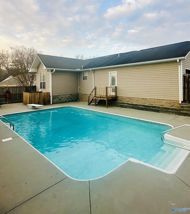 view of pool with a diving board, a patio, fence, and a fenced in pool