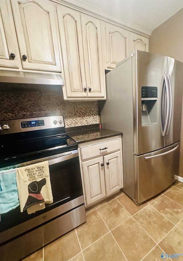 kitchen featuring under cabinet range hood, light tile patterned floors, cream cabinets, and stainless steel appliances