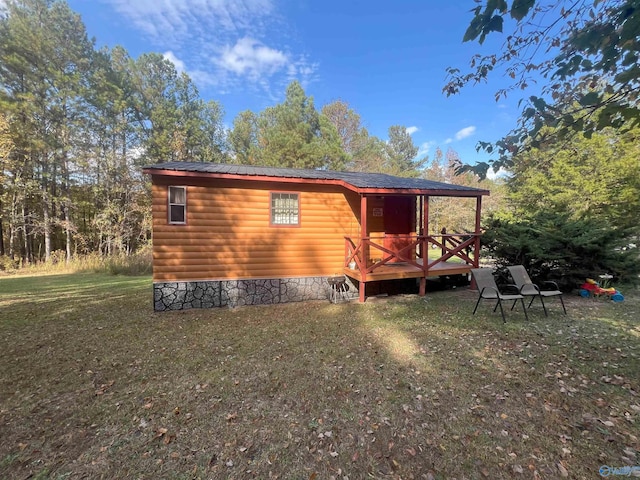 back of property featuring a wooden deck and a lawn