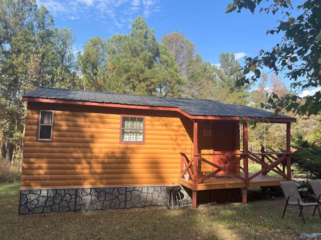 view of side of home with a deck and a lawn