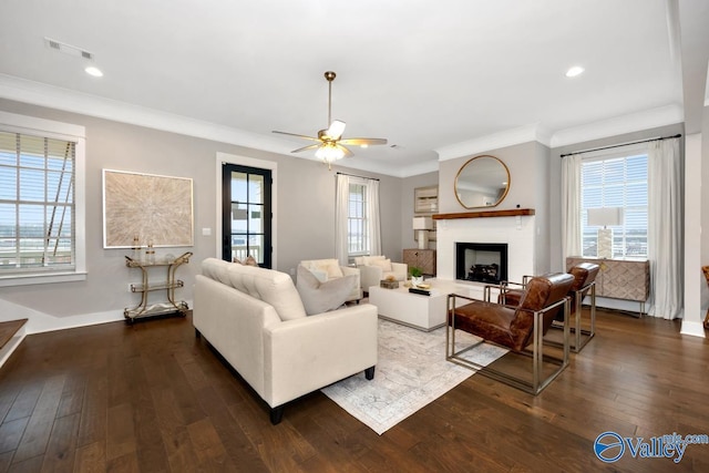 living room featuring ornamental molding, a healthy amount of sunlight, and dark hardwood / wood-style flooring