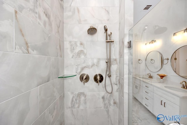 bathroom with vanity, tiled shower, and tile walls