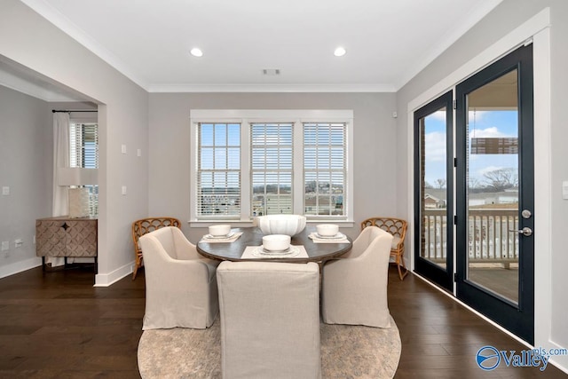 dining area with ornamental molding, a wealth of natural light, and dark hardwood / wood-style flooring