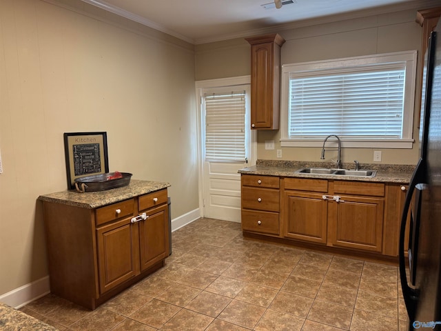 kitchen with black refrigerator, sink, tile patterned flooring, and ornamental molding