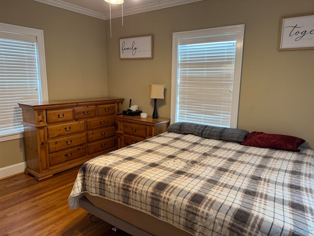 bedroom featuring multiple windows, crown molding, and wood-type flooring