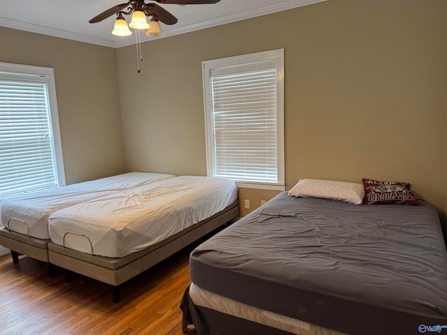 bedroom featuring ceiling fan, hardwood / wood-style floors, and crown molding