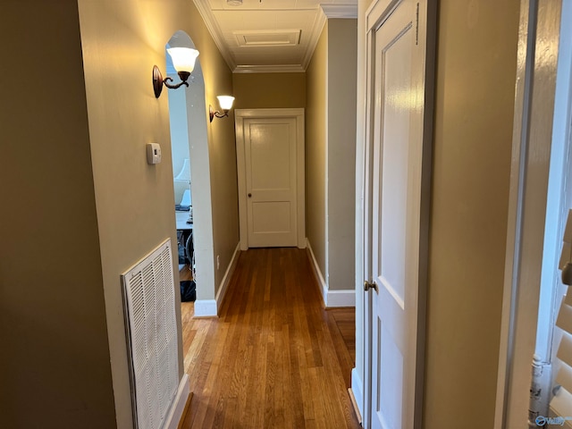 corridor with wood-type flooring and ornamental molding