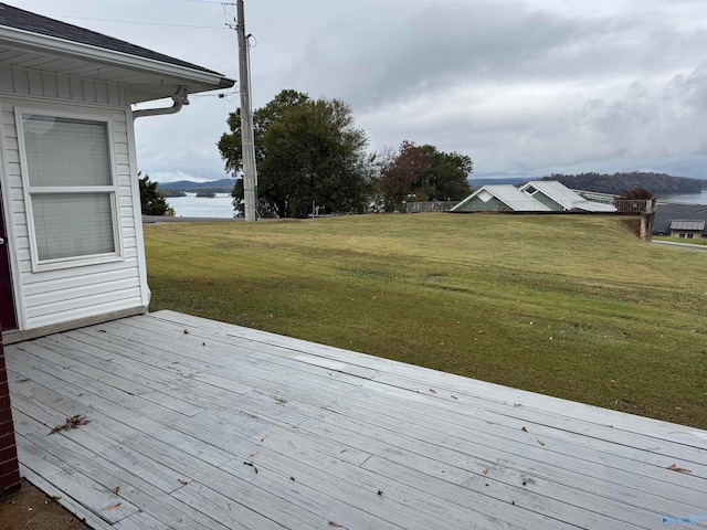 deck with a lawn and a water view