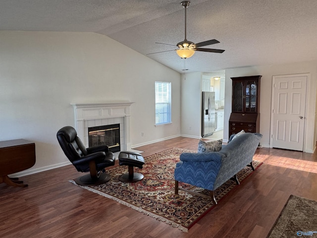 living room with baseboards, a ceiling fan, lofted ceiling, and wood finished floors