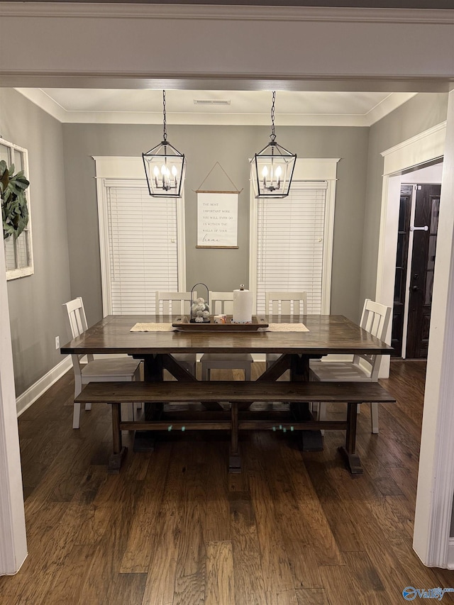 dining space featuring ornamental molding, dark wood-type flooring, and a notable chandelier