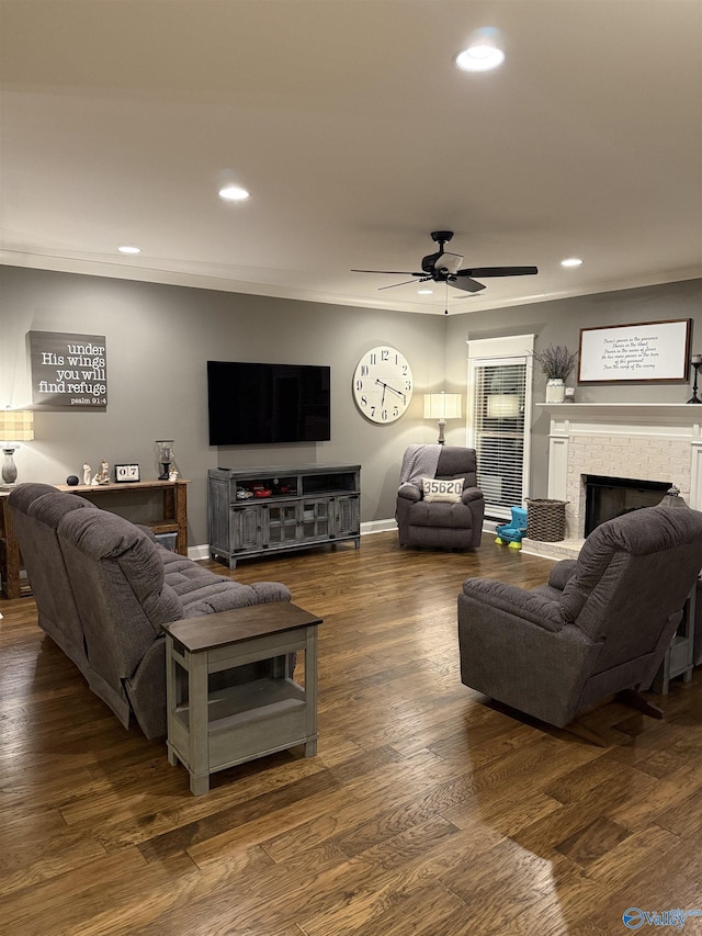 living room featuring dark wood-type flooring, ceiling fan, and crown molding