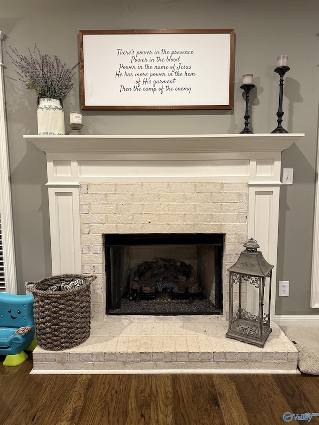 details featuring hardwood / wood-style flooring and a brick fireplace