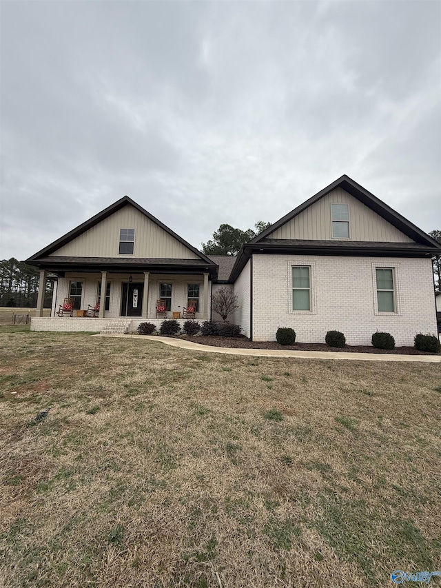 view of front of house featuring covered porch and a front lawn