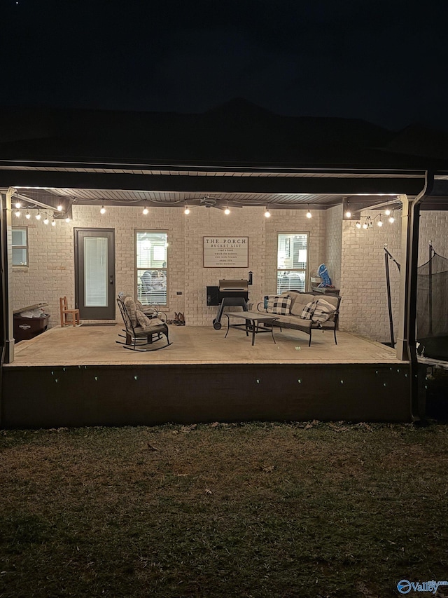 back house at night featuring a patio area