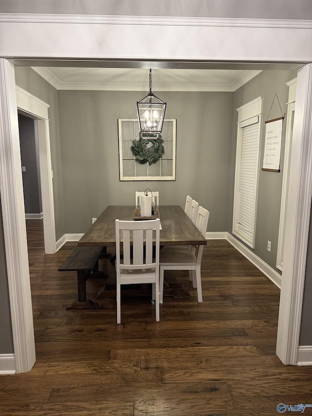 dining space featuring ornamental molding, dark wood-type flooring, and a chandelier