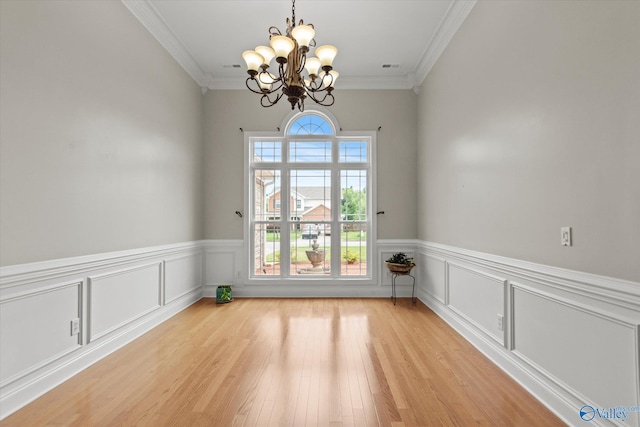 208 Honor Way, Madison, AL 35758 - spare room featuring a chandelier, light wood-type flooring, crown molding, and wainscoting