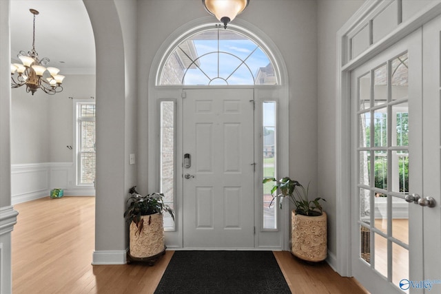 208 Honor Way, Madison, AL 35758 - foyer with a chandelier, wood finished floors, crown molding, a wainscoted wall, and arched walkways