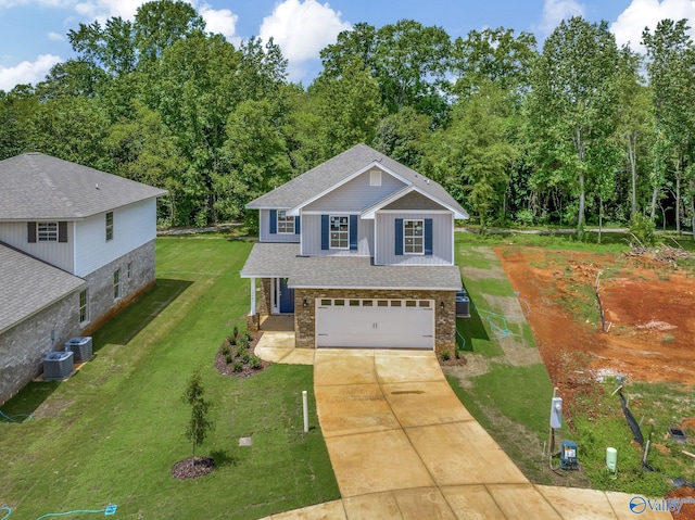 view of front of property featuring central AC unit, a garage, and a front lawn